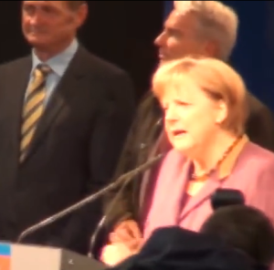 Merkel redet unberiirt weiter, als spräche sie mit einer Wand (Bildschirmfotoausriß: YT-Video)